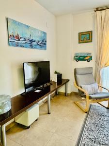 a living room with a television and a chair at El Rincón Azul Benicasim centro in Benicàssim