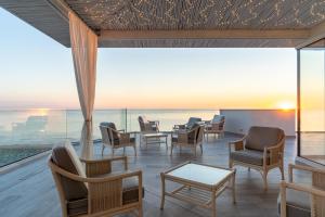 a room with chairs and tables and a view of the ocean at Riviera Hotel in Senigallia
