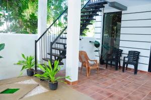 a patio with black chairs and stairs on a house at Sky Haven in Matara