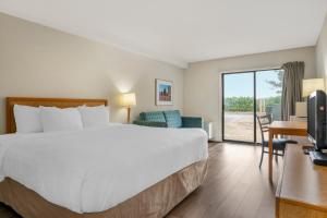 a hotel room with a large bed and a sliding glass door at Rodeway Inn in Saint John +35 photos
