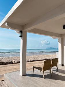 a bench sitting under a pavilion at the beach at Cape and Sea Resort in Ban Boet