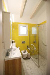 a bathroom with a toilet and a sink and a shower at Amanda's House in Poros