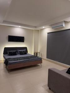 a bedroom with a bed and a large screen at The Cubee Nest- Luxury 1BHK in Central Bahria Enclave in Islamabad