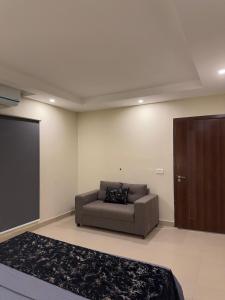 a living room with a couch and a brown door at The Cubee Nest- Luxury 1BHK in Central Bahria Enclave in Islamabad