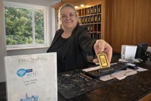 a woman sitting at a desk holding a piece of equipment at HOTEL TRIONFAL - Fronte Mare - Vicinissimi al Centro in Milano Marittima