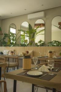a dining room with tables and chairs and mirrors at Hotel Caseros Salta in Salta