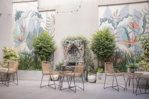 a table and chairs in front of a wall with a mural at Hotel Caseros Salta in Salta