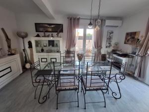 a dining room with a glass table and chairs at Grande Chambre double in Sérignan