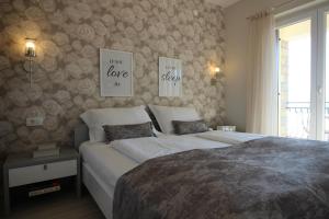 a bedroom with a bed and two posters on the wall at LadyM in Rabac