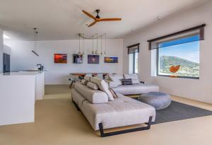 a living room with two couches and a ceiling fan at Skylines Estate Paros in Kampos Paros