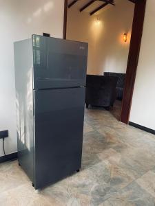 a black refrigerator sitting in a room at RailNest in Talpe