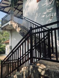 a stair railing next to a white house at RailNest in Talpe