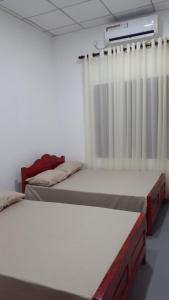 a room with two beds and a window at Thoughtfully Updated 1960s Jaffna House in Jaffna