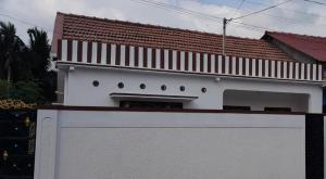 a white building with a white fence in front of it at Thoughtfully Updated 1960s Jaffna House in Jaffna