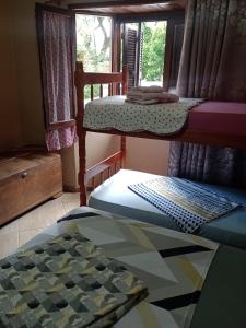 a bedroom with two bunk beds and a window at Pousada Nilda in Pântano Grande