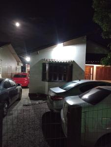 a group of cars parked outside a house at night at Pousada Nilda in Pântano Grande