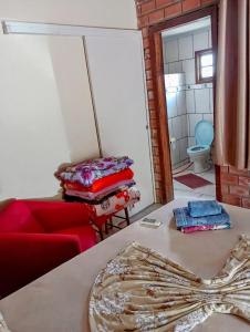 a living room with a red couch and a table at Pousada Nilda in Pântano Grande +1 photo