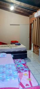 a bedroom with two beds and a rug on the floor at Pousada Nilda in Pântano Grande