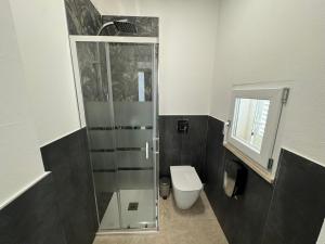 ein Badezimmer mit Glasdusche und Toilette in der Unterkunft Isamar in Grosseto