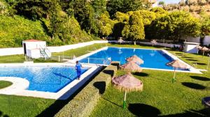 a man standing in front of a swimming pool at La Escribana in Constantina