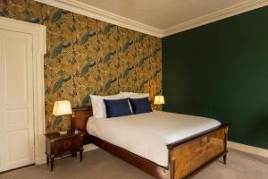 a bedroom with a bed with a green wall at Noan Country House B&B in Cashel