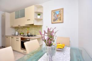 a kitchen with a glass table with flowers in a vase at Apartment Tina Split in Split