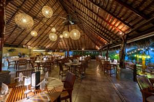 an empty restaurant with tables and chairs and chandeliers at Tango Mar Beachfront Boutique Hotel & Villas in Tambor