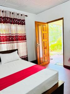 a bedroom with a bed and a door with a window at GREENISH INN (ROOMS) in Nanu Oya