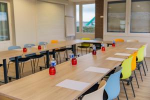 a classroom with tables and chairs with soda bottles on them at Logis Hôtel Alizéa Le Mans Nord in Saint-Saturnin