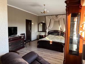 a bedroom with a bed and a couch at Готель Козацький in Zvenyhorodka