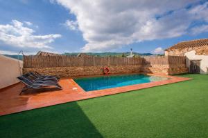 a swimming pool in a yard with two chairs at Catalunya Casas Captivating Villa in the Vineyard close to Sitges in Bisbal del Penedès