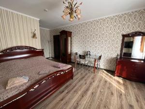 a bedroom with a bed and a table and a chandelier at Готель Козацький in Zvenyhorodka