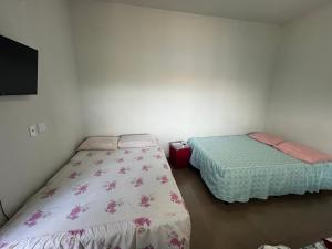 a room with two beds and a flat screen tv at Residencial Jasmim quarto Standard 01 in Palmas