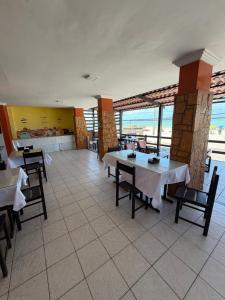 ein Restaurant mit Tischen und Stühlen und Meerblick in der Unterkunft Hotel Pousada Sol Beira-mar in Natal
