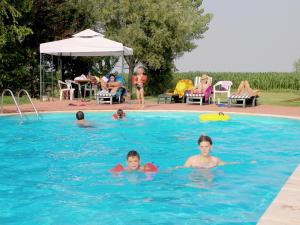 a group of children swimming in a swimming pool at Pet-Friendly Nature Escape in Pontecchio Polesine