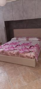 a bed with a pink blanket on top of it at Casa Graziosa - Casa vacanze a Policoro in Policoro