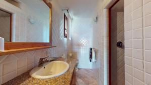 a bathroom with a sink and a mirror at Villetta Ginepri in Cannigione +16 photos