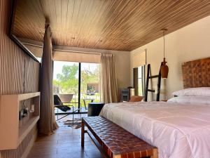a bedroom with a bed and a large window at LÜN Lodges in Chacras de Coria