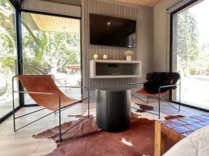 a living room with two chairs and a tv at LÜN Lodges in Chacras de Coria