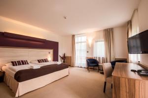 a hotel room with a bed and a flat screen tv at Hotel Golf Resort Olomouc in Dolany +50 photos