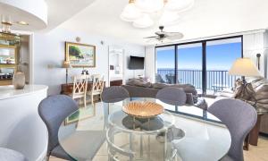 a living room with a glass table and chairs at One Seagrove Place 1505 in Santa Rosa Beach