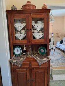 a wooden cabinet with dishes in it in a living room at Villa Excelsior in Korinthos