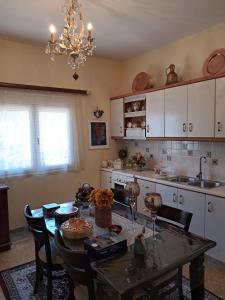 a kitchen with a table with chairs and a chandelier at Villa Excelsior in Korinthos