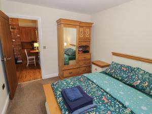 a bedroom with a bed and a dresser and a mirror at Otter's Rest in Droitwich