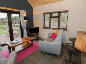 a living room with a couch and a table at The Barn on The Lagoon in Droitwich +15 photos