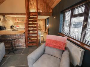 a living room with a couch and a kitchen at The Barn on The Lagoon in Droitwich