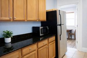 a kitchen with a refrigerator and a microwave at Downtown Gem • King Bed • Fast WIFI in Salt Lake City +5 photos