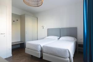 a bedroom with a large white bed with white sheets at Residence Atlantico in Lido di Jesolo +51 photos