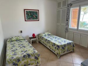 a bedroom with two beds and a window at Precioso Dpto a 20m de la playa Con Aire Acondicionado en Ambos Dormitorios Club Casablanca in Same
