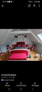 a bedroom with a bed with red pillows and chairs at suite nature huelgoat in Bannalec